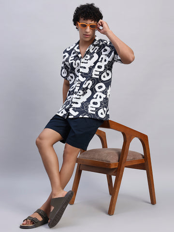 Model posing standing with chair styled in navy blue oversized printed shirt for men-Smokhead