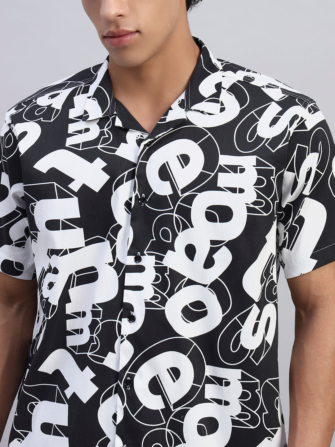 Close-up of black and white bold typography abstract graphic on men's short-sleeve shirt — SMOKHEAD premium streetwear details