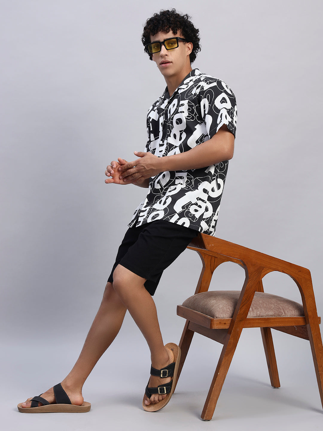 Full look: Men's black and white abstract graphic shirt paired with black shorts and sandals — SMOKHEAD summer casual streetwear outfit