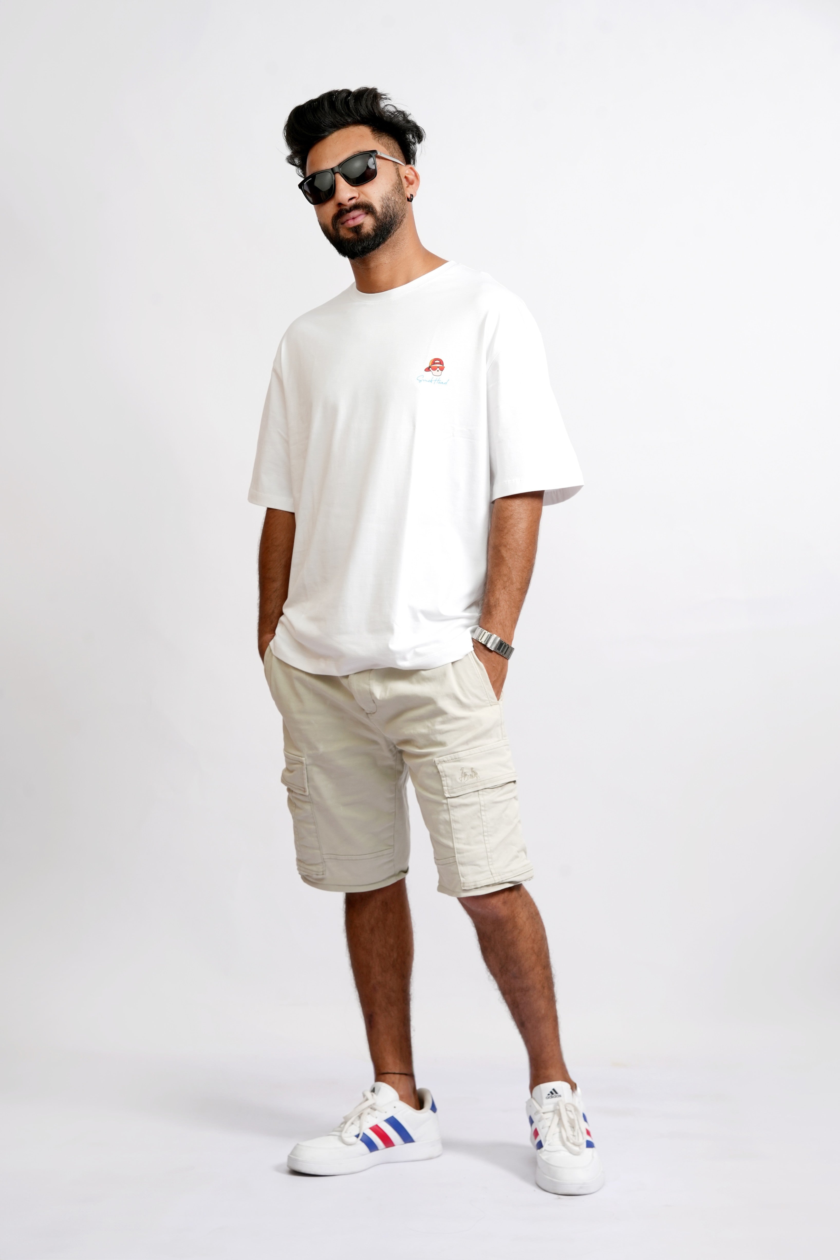 Full Look – SMOKHEAD Men's White Oversized Graphic T-Shirt Styled with Beige Cargo Shorts and White Sneakers for Streetwear Aesthetic